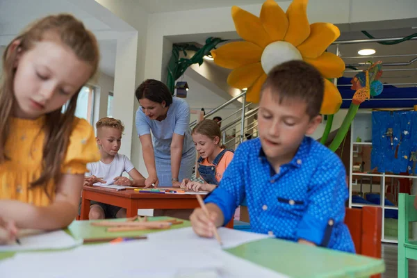 보육원이나 교실에서 교사와 그림을 그리는 창의적 아이들 — 스톡 사진