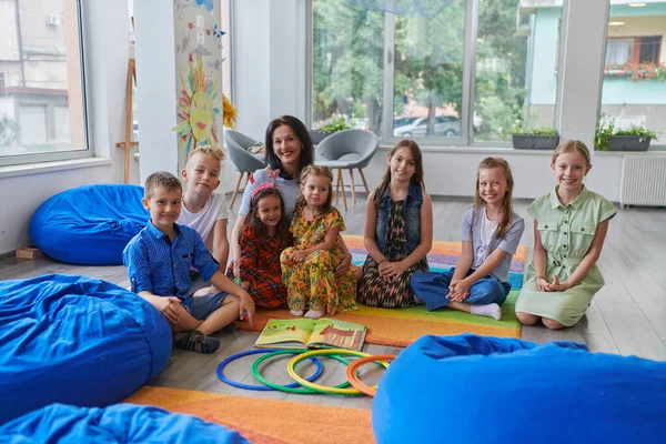 Lycklig Kvinnlig Lärare Som Sitter Och Leker Handlekar Med Grupp — Stockfoto