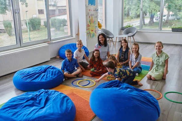 Bir Grup Küçük Okul Çocuğuyla Oyunları Oynayan Mutlu Bir Bayan — Stok fotoğraf
