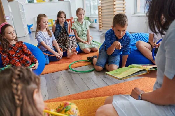 Eine Glückliche Lehrerin Sitzt Und Spielt Handspiele Mit Einer Gruppe — Stockfoto
