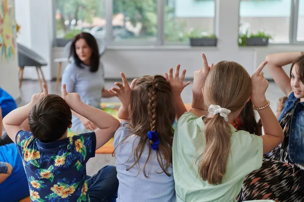 Una Maestra Feliz Sentada Jugando Juegos Manos Con Grupo Niños —  Fotos de Stock