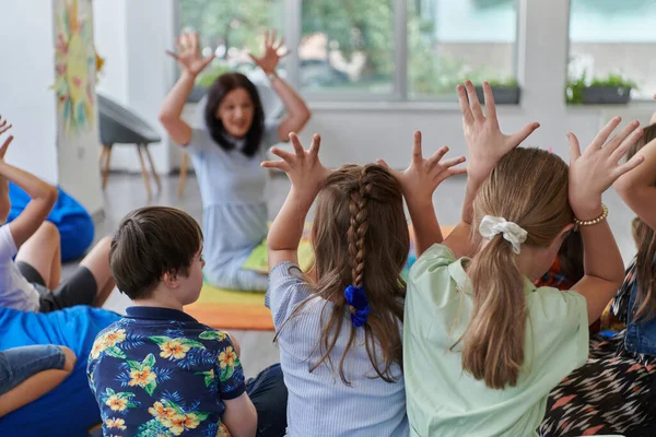 Bir Grup Küçük Okul Çocuğuyla Oyunları Oynayan Mutlu Bir Bayan — Stok fotoğraf