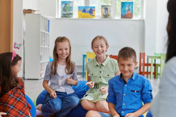 Happy Female Teacher Sitting Playing Hand Games Group Little Schoolchildren — Stock Photo, Image