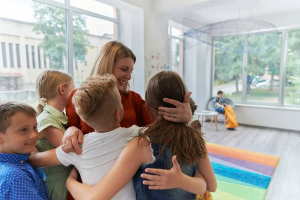 Dziecko Przytulające Nauczyciela Nowoczesnym Przedszkolu Wysokiej Jakości Zdjęcie — Zdjęcie stockowe