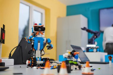 Bir öğrenci, yeni buluşu olan robotik kolu laboratuvarda test ediyor. Araştırmasının ve teknolojik becerisinin doruk noktasını gösteriyor.