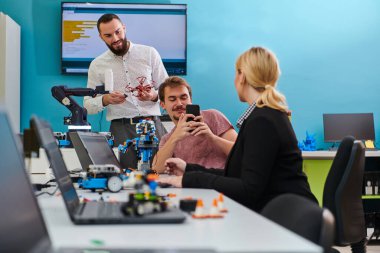 Robot laboratuvarında birlikte çalışan bir grup iş arkadaşı, robotik ve 3D yazıcıların karmaşık alanlarına odaklanıyor. Araştırmalarında yeniliğe olan adanmışlıklarını gösterirler.