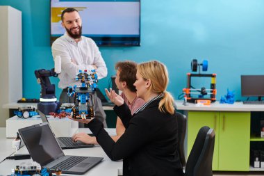 Robot laboratuvarında birlikte çalışan bir grup iş arkadaşı, robotik ve 3D yazıcıların karmaşık alanlarına odaklanıyor. Araştırmalarında yeniliğe olan adanmışlıklarını gösterirler.