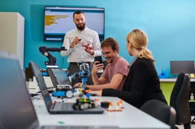Robot laboratuvarında birlikte çalışan bir grup iş arkadaşı, robotik ve 3D yazıcıların karmaşık alanlarına odaklanıyor. Araştırmalarında yeniliğe olan adanmışlıklarını gösterirler.