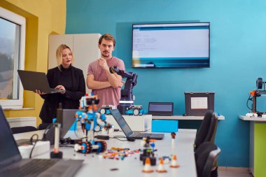 Robot laboratuvarında birlikte çalışan bir grup iş arkadaşı, robotik ve 3D yazıcıların karmaşık alanlarına odaklanıyor. Araştırmalarında yeniliğe olan adanmışlıklarını gösterirler.