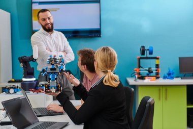 Robot laboratuvarında birlikte çalışan bir grup iş arkadaşı, robotik ve 3D yazıcıların karmaşık alanlarına odaklanıyor. Araştırmalarında yeniliğe olan adanmışlıklarını gösterirler.