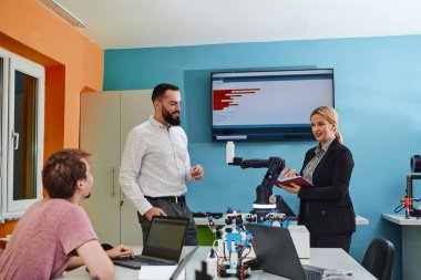 Robot laboratuvarında birlikte çalışan bir grup iş arkadaşı, robotik ve 3D yazıcıların karmaşık alanlarına odaklanıyor. Araştırmalarında yeniliğe olan adanmışlıklarını gösterirler.