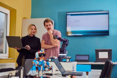 Robot laboratuvarında birlikte çalışan bir grup iş arkadaşı, robotik ve 3D yazıcıların karmaşık alanlarına odaklanıyor. Araştırmalarında yeniliğe olan adanmışlıklarını gösterirler.