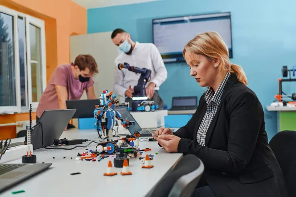 Kobieta Siedząca Laboratorium Rozwiązująca Problemy Analizująca Weryfikację Robotów Tle Koledzy — Zdjęcie stockowe