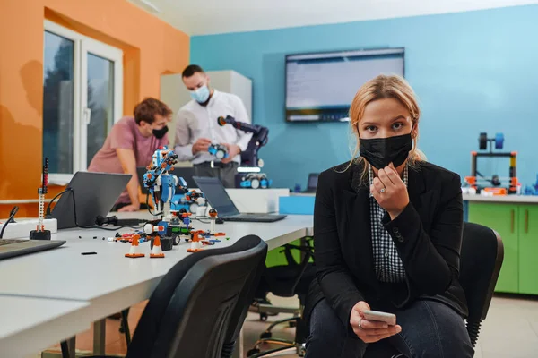 Жінка Захисній Масці Стоїть Лабораторії Поки Колеги Тестують Новий Роботизований — стокове фото