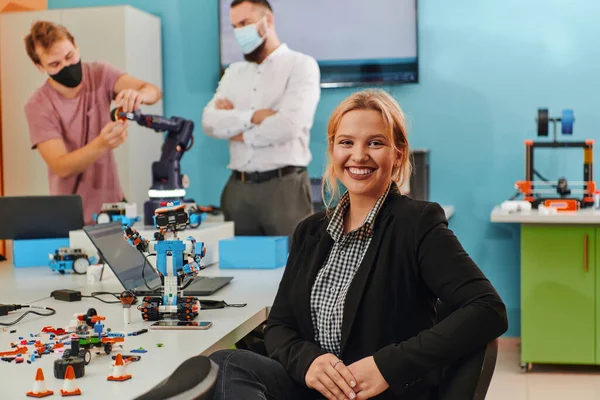 Žena Sedící Laboratoři Zatímco Její Kolegové Testují Nový Robotický Vynález — Stock fotografie
