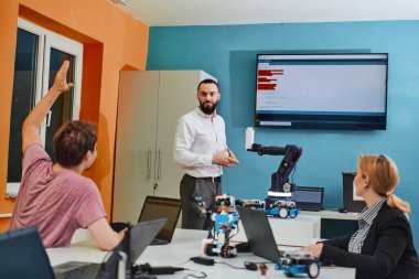 Robot laboratuvarında birlikte çalışan bir grup iş arkadaşı, robotik ve 3D yazıcıların karmaşık alanlarına odaklanıyor. Araştırmalarında yeniliğe olan adanmışlıklarını gösterirler.