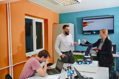 Robot laboratuvarında birlikte çalışan bir grup iş arkadaşı, robotik ve 3D yazıcıların karmaşık alanlarına odaklanıyor. Araştırmalarında yeniliğe olan adanmışlıklarını gösterirler.