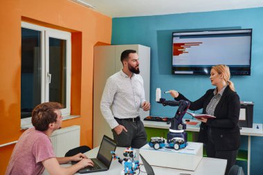 Robot laboratuvarında birlikte çalışan bir grup iş arkadaşı, robotik ve 3D yazıcıların karmaşık alanlarına odaklanıyor. Araştırmalarında yeniliğe olan adanmışlıklarını gösterirler.