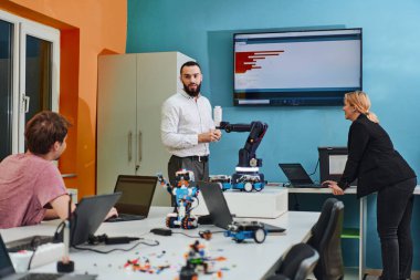 Robot laboratuvarında birlikte çalışan bir grup iş arkadaşı, robotik ve 3D yazıcıların karmaşık alanlarına odaklanıyor. Araştırmalarında yeniliğe olan adanmışlıklarını gösterirler.