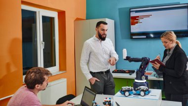 Robot laboratuvarında birlikte çalışan bir grup iş arkadaşı, robotik ve 3D yazıcıların karmaşık alanlarına odaklanıyor. Araştırmalarında yeniliğe olan adanmışlıklarını gösterirler.