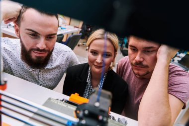 Robot laboratuvarında birlikte çalışan bir grup iş arkadaşı, robotik ve 3D yazıcıların karmaşık alanlarına odaklanıyor. Araştırmalarında yeniliğe olan adanmışlıklarını gösterirler.