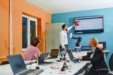 Robot laboratuvarında birlikte çalışan bir grup iş arkadaşı, robotik ve 3D yazıcıların karmaşık alanlarına odaklanıyor. Araştırmalarında yeniliğe olan adanmışlıklarını gösterirler.
