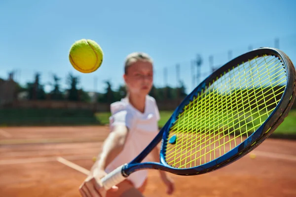 在阳光灿烂的日子里 一个年轻姑娘在一场比赛中表现出专业网球技巧的近照 四周环绕着现代网球场的美学图案 — 图库照片