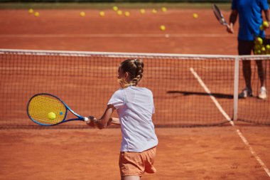Profesyonel bir tenisçi ve onun koçu tenis kortunda güneşli bir günde antrenman yapıyorlar. Profesyonel bir tenisçinin antrenmanı ve hazırlığı.