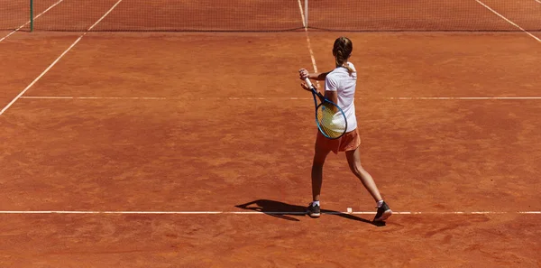 テニスコートのモダンな美学に囲まれ 晴れた日に競争力のある試合でプロのテニスのスキルを示す若い女の子 — ストック写真