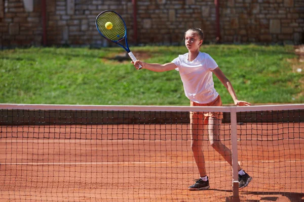 テニスコートのモダンな美学に囲まれ 晴れた日に競争力のある試合でプロのテニスのスキルを示す若い女の子 — ストック写真