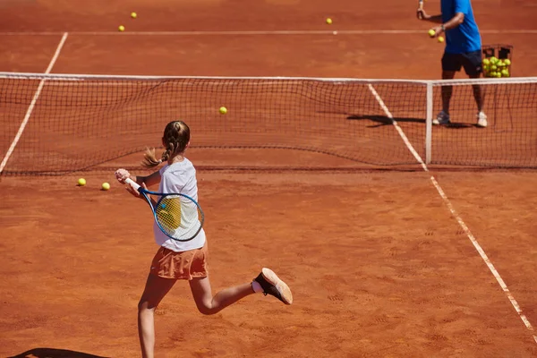A professional tennis player and her coach training on a sunny day at the tennis court. Training and preparation of a professional tennis player.