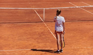 Profesyonel bir tenisçi ve onun koçu tenis kortunda güneşli bir günde antrenman yapıyorlar. Profesyonel bir tenisçinin antrenmanı ve hazırlığı.