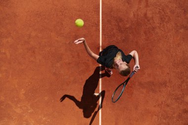 Profesyonel bir bayan tenisçinin üst görüntüsü tenis topunu sahada hassas ve güçlü bir şekilde servis eder.. 