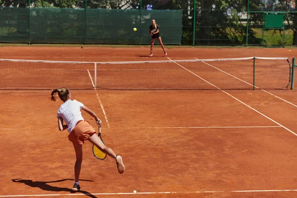 在阳光灿烂的日子里 年轻姑娘们参加了一场活泼的网球比赛 展示了她们在现代网球场上的技巧和热情 — 图库照片