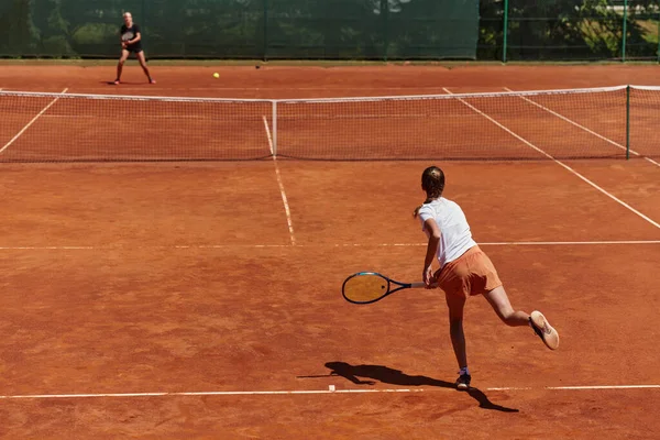 在阳光灿烂的日子里 年轻姑娘们参加了一场活泼的网球比赛 展示了她们在现代网球场上的技巧和热情 — 图库照片
