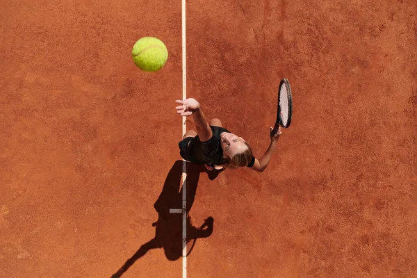 一位职业女子网球选手的头像精准而有力地在球场上为网球服务 — 图库照片
