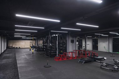 An empty modern gymnasium with a variety of equipment, offering a spacious, functional, and well-equipped training facility for workouts, fitness, and strength training. clipart