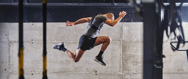 Hombre Musculoso Capturado Aire Mientras Salta Gimnasio Moderno Mostrando Atletismo — Foto de Stock