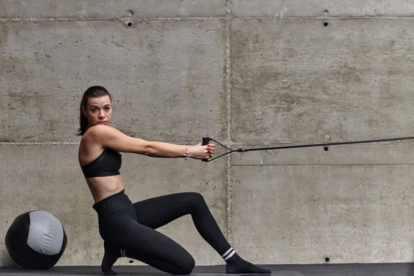 現代のジムのフィット感のある女性は 彼女のフィットネスの目標に向かって動作するように 彼女の強さと彫刻の筋肉を紹介し 決意で腕の練習を実行します — ストック写真