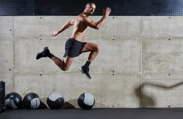 Muskularny Mężczyzna Złapany Powietrze Skacze Nowoczesnej Siłowni Pokazując Swój Atletyzm — Zdjęcie stockowe