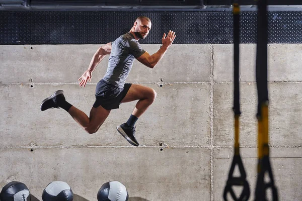 Muskularny Mężczyzna Złapany Powietrze Skacze Nowoczesnej Siłowni Pokazując Swój Atletyzm — Zdjęcie stockowe