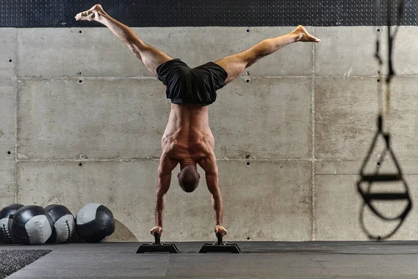 立ち位置に筋肉の男 現代のジムで彼の全体的な体の安定性と強さを向上させるために様々な演習を実行しながら 彼の優れたバランスと体の制御を紹介します — ストック写真