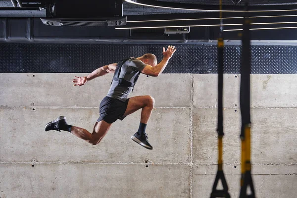 현대적 체육관에서 점프를 하다가 공중에 근육질의 남자가고 관련된 일과를 자신의 — 스톡 사진