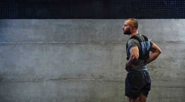 Spor salonunda idmana hazırlanan kaslı bir adam limitlerini zorlamaya ve fitness hedeflerine ulaşmaya hazırlanırken kararlılık ve odaklanmayı yayar.