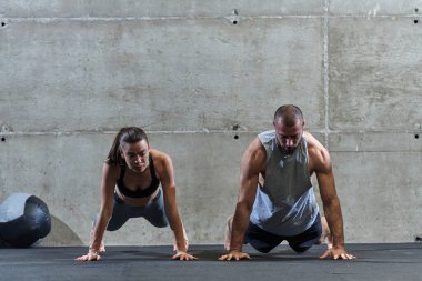 Spor salonunda birlikte esneme egzersizleri yapan çekici bir çift fitness, esneklik ve genel refahı için kendilerini adadıklarını gösteriyorlar. Senkronize hareketlerle...