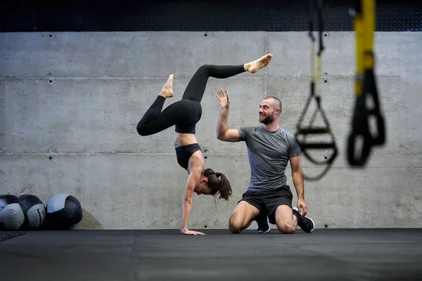Ein Muskulöser Mann Unterstützt Eine Fitte Frau Einem Modernen Fitnessstudio — Stockfoto