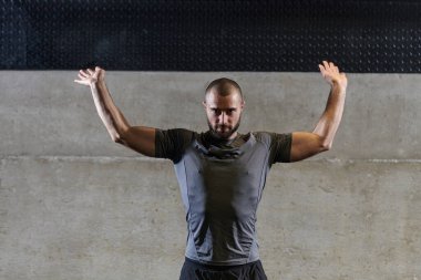 Modern spor salonunda kolları ve vücut kasları için egzersiz yapan kaslı bir adam. .