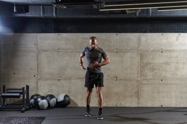 Modern spor salonunda kolları ve vücut kasları için egzersiz yapan kaslı bir adam. .