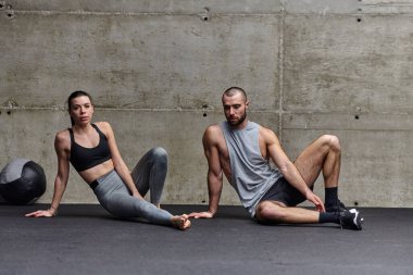 Spor salonunda birlikte esneme egzersizleri yapan çekici bir çift fitness, esneklik ve genel refahı için kendilerini adadıklarını gösteriyorlar. Senkronize hareketlerle...