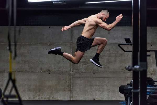 Ein Muskulöser Mann Der Beim Springen Einem Modernen Fitnessstudio Die — Stockfoto
